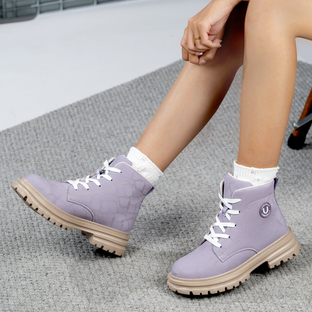 Woman wearing light purple 596 steel toe work boots while seated